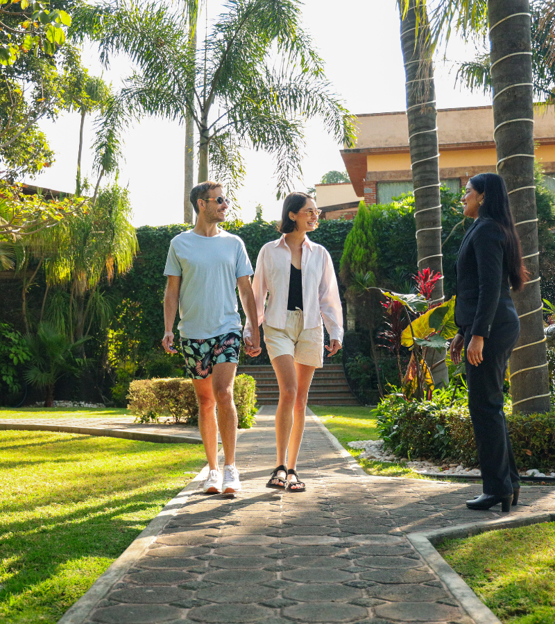 Huéspedes caminando por los jardines de La Buena Vibra